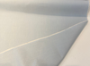 Sunbrella Play Sky blue chambray solid fabric unrolled on the cutting table