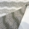 Close view of the Sunbrella Swoon Sage weave with green leaf motifs on a linen-like white ground