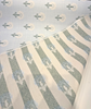 Sunbrella Mira Spring floral pattern showing stylized blooms with teal-green stems on light blue