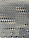 Close-up of the woven diamond trellis and dot pattern on dark teal