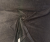Charcoal-black mohair upholstery velvet on the bolt showing the smoky gray flecks