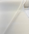 Warm cream Crypton velvet upholstery fabric laid flat on the cutting table