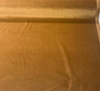 Crypton Sintra Rattan caramel performance velvet on the roll across the cutting table