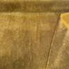 Cognac gold mohair velvet unrolled on the cutting table with a corner folded back
