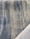 Mirage Galaxy mohair velvet unrolled across the cutting table, showing denim blue and greige streaks