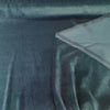 Deep teal Crypton velvet upholstery fabric laid flat on the roll