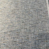 Light blue tweed chenille Crypton Rushdie fabric laid flat on the roll
