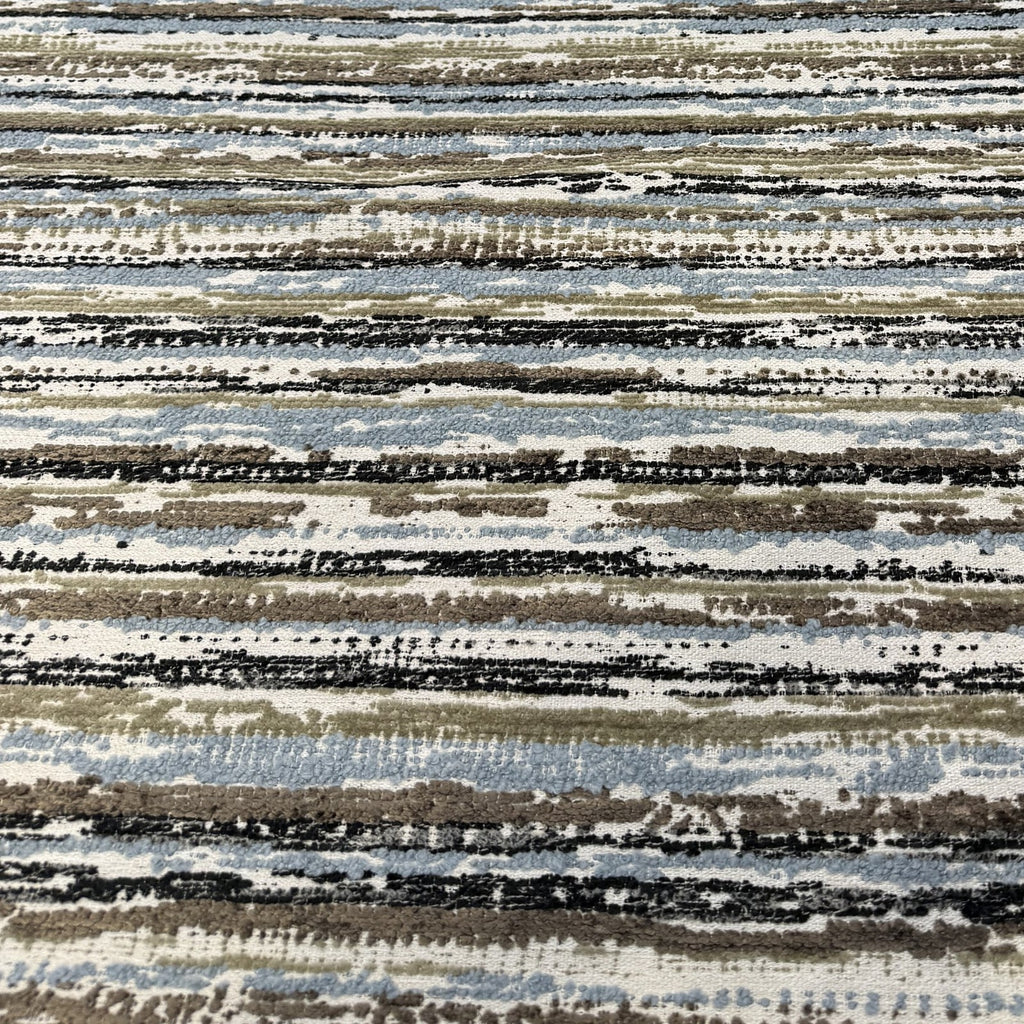 Swavelle Desert Storm Blue striped chenille upholstery fabric laid flat on the roll