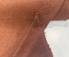 Rust terracotta fabric with a nubby boucle and chenille texture